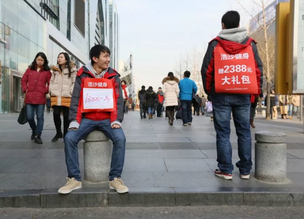 浩沙健身工作人员身穿促销广告,在北京西单路边招揽生意.