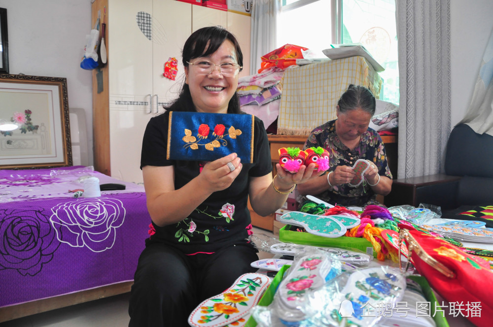 8月20日,陕西省延川县郭家沟村妇女张东萍正在展示手工刺绣老虎鞋和