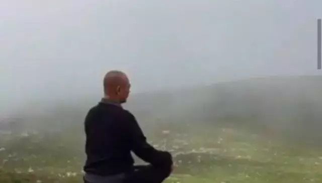 他端坐在山顶,面对着茫茫山野,正静心打坐,看起来状态良好,平静宁和.