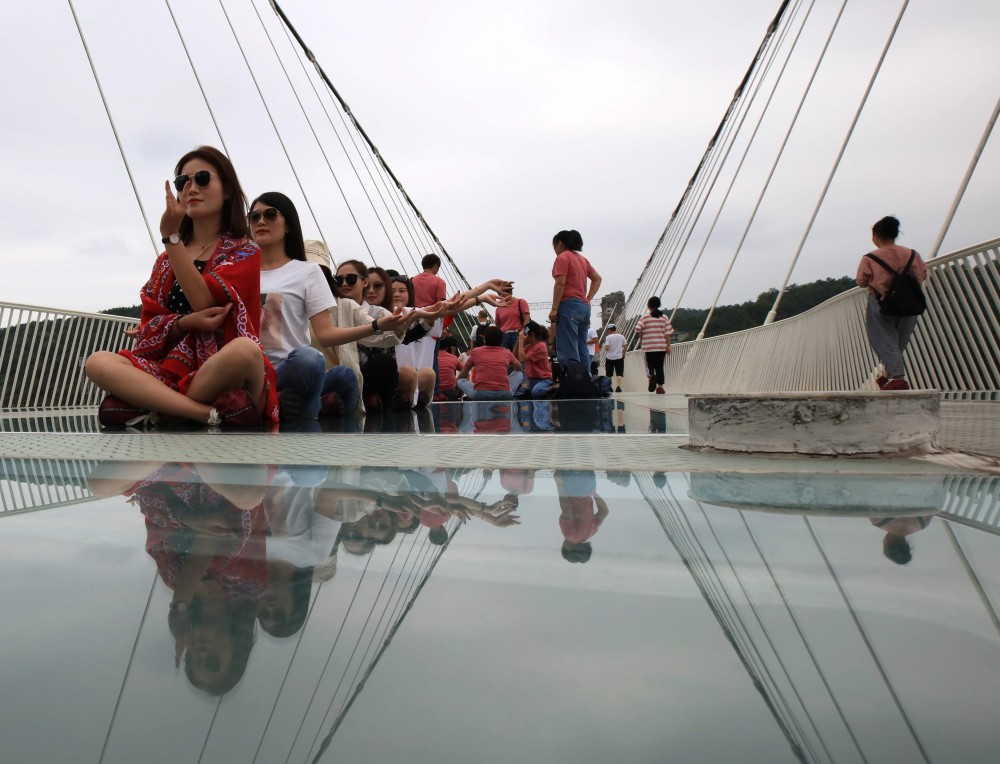9月14日,游人在位于湖南张家界大峡谷风景区的高空峡谷玻璃桥上参观