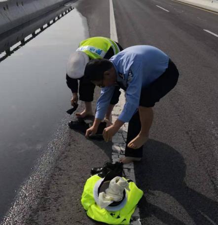 脱去鞋袜撸起袖子,交警大队长用手掏淤泥清理高速路排水孔