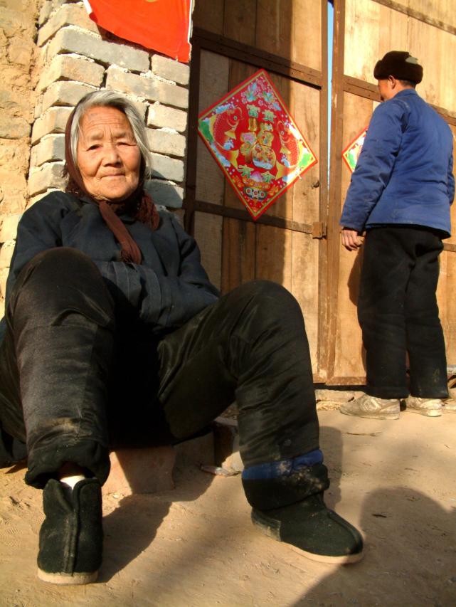 前些年回家,看到邻居婆婆穿着偏襟衣服,坐在门口晒太阳,她的儿子在贴