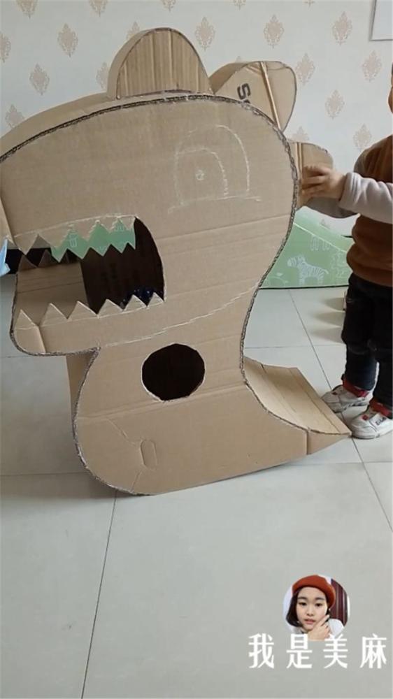 爸爸用纸箱给儿子做了只大恐龙,在公园里跑来跑去,吓坏了小朋友