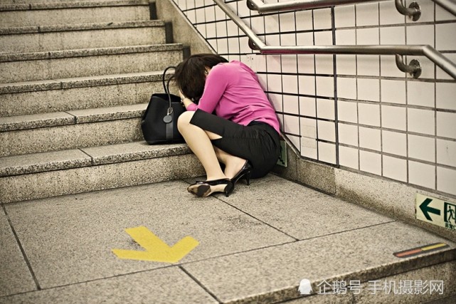 图为一位女子因为聚会喝醉了,直接在地下通道的楼梯台阶上睡着了.
