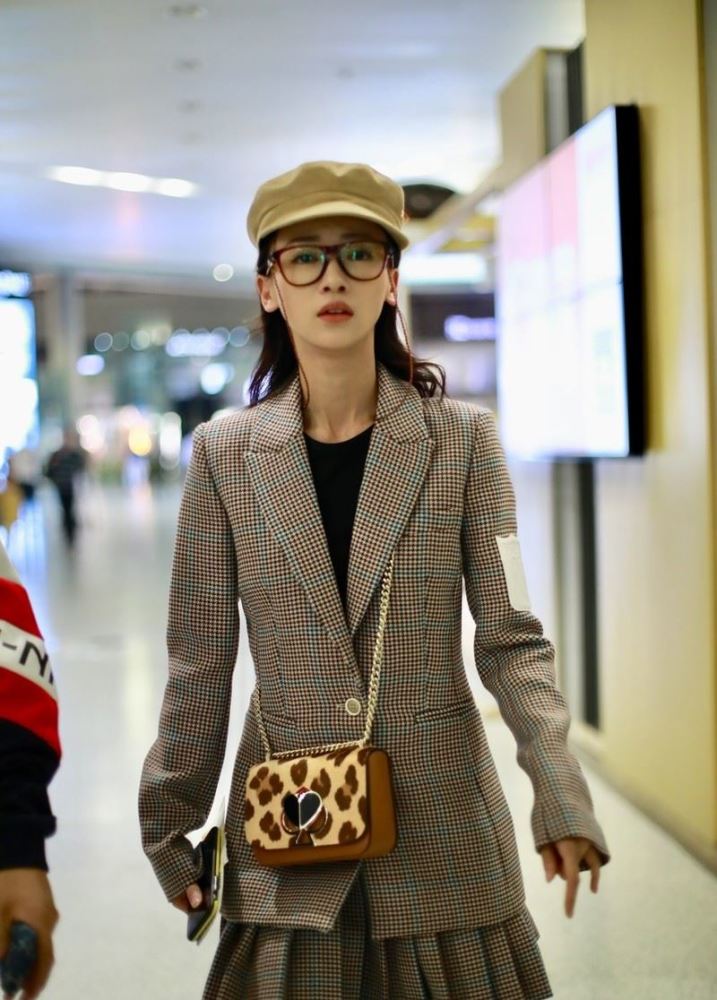 女演员吴谨言现身机场,穿格纹西装百褶裙套装,戴报童帽青春靓丽