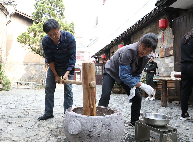 然后将热腾腾的糯米饭放入石臼中敲打 接下来就到了最关键的打麻糍