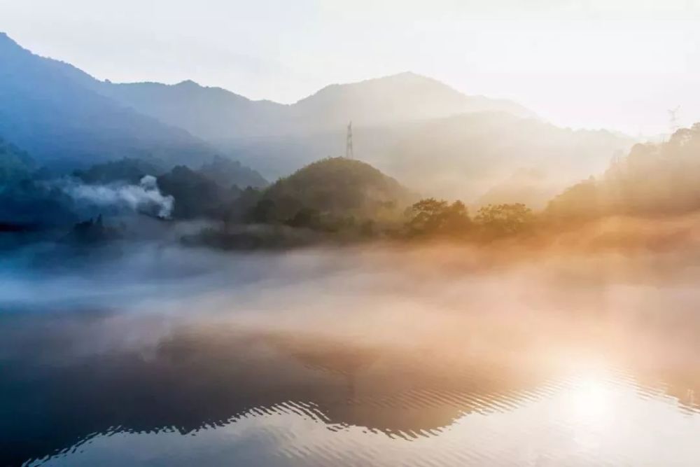 清晨的小东江,云雾弥漫,远处的山和树木隐隐约约,如同置身在梦幻的