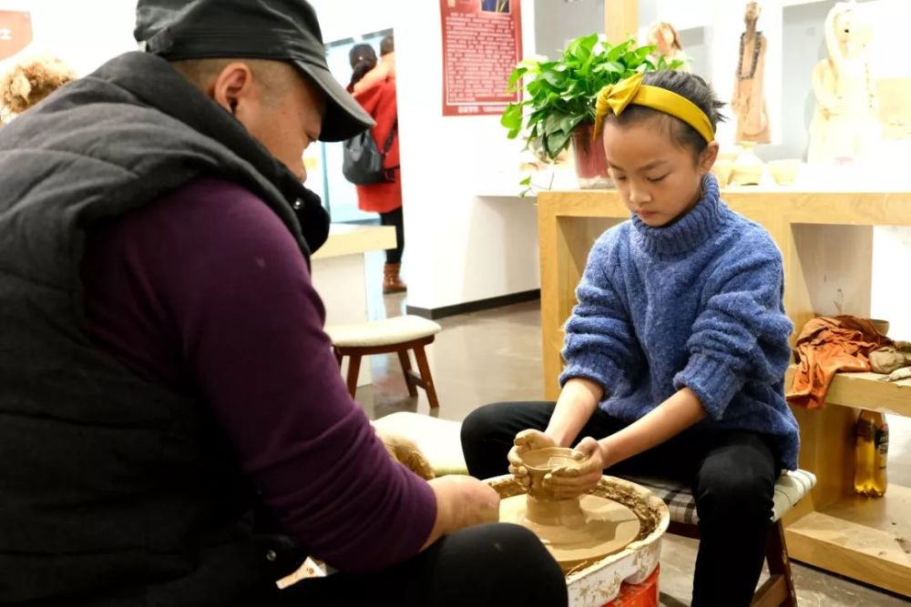 几对亲子在花灯坊跟着老师学习体验花灯制作的过程,小朋友们都做的