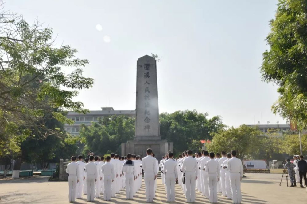 官兵们在遂溪人民抗法纪念碑前感悟革命烈士的战斗精神,面对党旗重温