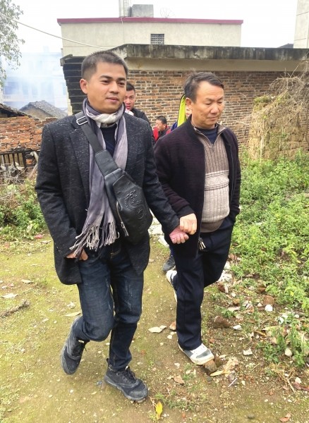 12月1日,邵阳新邵县新田铺镇,谢宗阳(左)的父亲牵着他的手一起回老家.