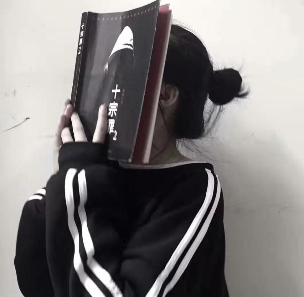 这个小姐姐手中拿着一本十宗罪的书,死死挡住自己的脸,暗黑色的封面像