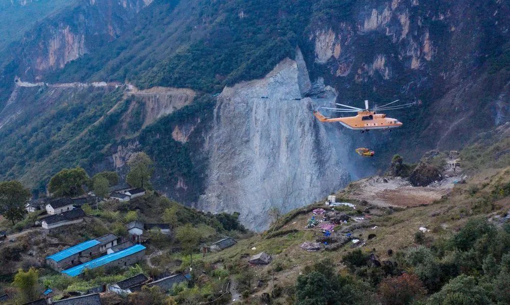 米-26重型直升机吊运一台挖掘机飞抵布拖县阿布洛哈村.