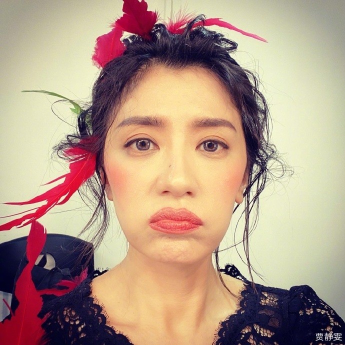 45岁贾静雯搞怪自黑,头插红羽毛口红涂出界,脸颊凹陷皱纹明显