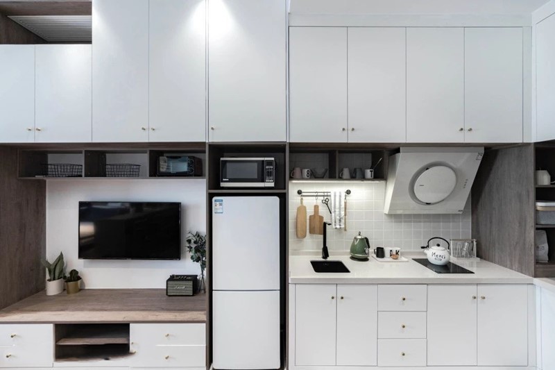 厨房旁边就是客厅电视柜,不过设计师用冰箱内嵌的设计,将厨房和客厅