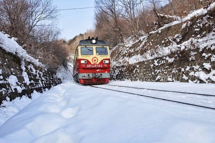 雪中绿皮火车穿山而过,下车乘客坐马车进村