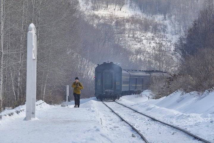 雪中绿皮火车穿山而过,下车乘客坐马车进村