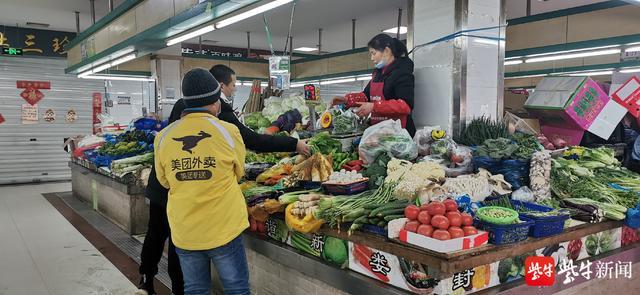 一名美团工作人员在金益菜场买菜