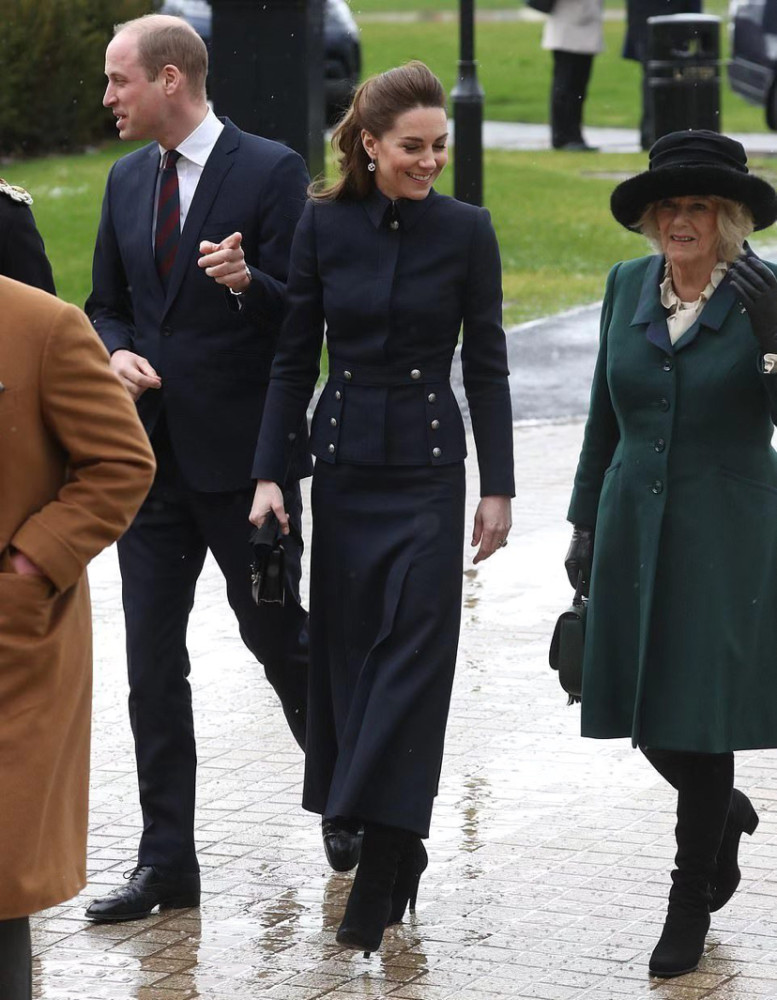 她穿着一件墨绿色的大衣,和凯特王妃一起走着