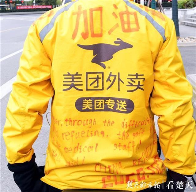 重点大学毕业的外卖小哥戴着口罩穿梭街头,他把加油写在背上,还有英文