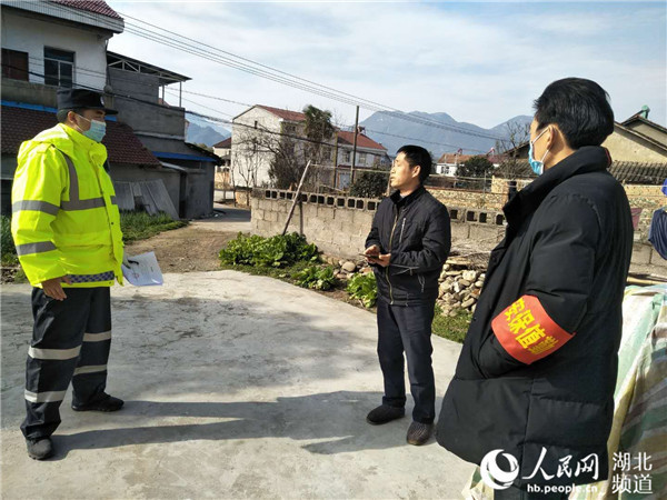 "2月18日,在湖北省远安县旧县镇鹿苑村,村警陈强对正在自家菜园摘菜的