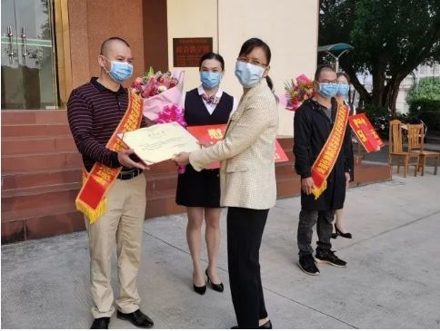 图为城区党委副书记吴秀红给志愿者颁发证书和慰问金