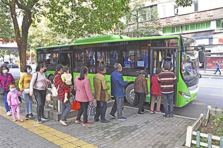 市民在忠县实验小学公交车站排队,有序乘坐公交车.