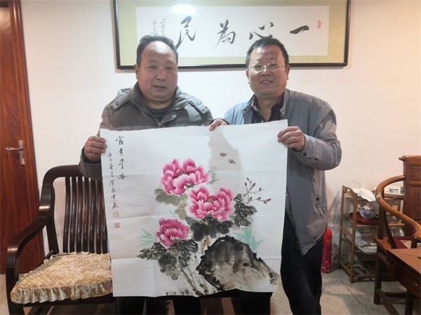 贺家宽(右)交流自己创作的国画牡丹作品