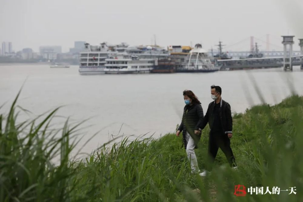 4月1日,汉口江滩,在岸边草丛散步的年轻人.有朋/摄
