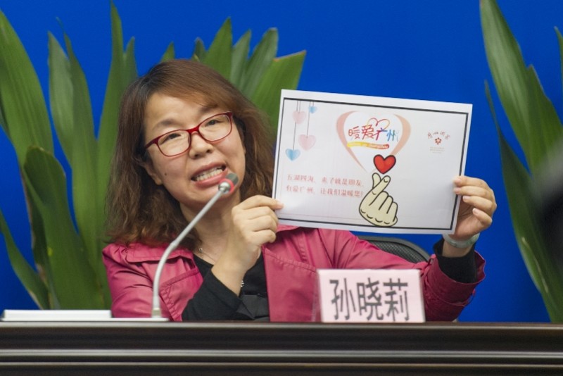 广州酒家集团党委副书记孙晓莉展示"暖爱广州"的爱心卡.