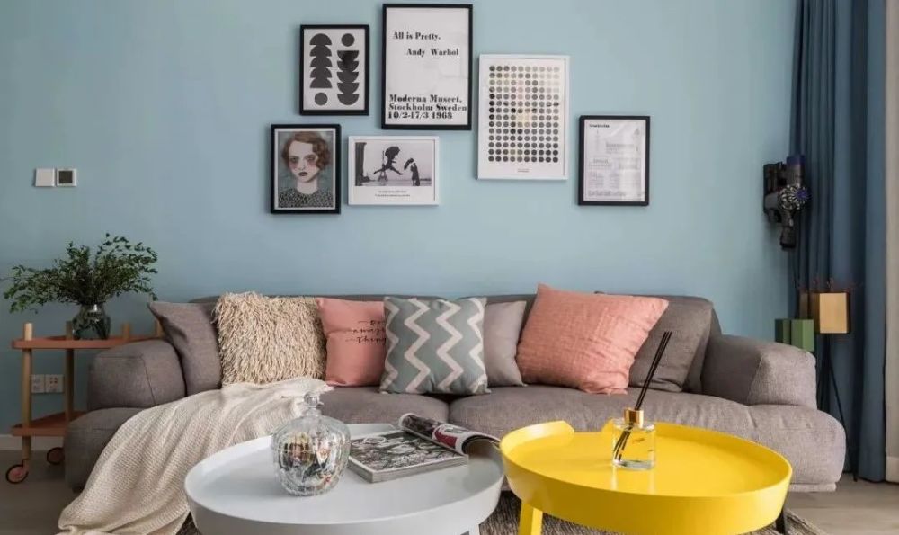 灰色布艺沙发搭配北欧风茶几,点缀色彩丰富的靠枕,跳跃的色彩让空间