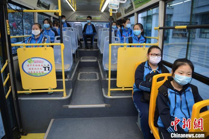 4月8日,学生们戴口罩乘坐学生公交专线,并保持距离. 刘文华 摄