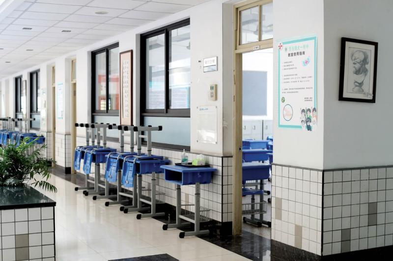 每间教室门口张贴"教室使用指南"和摆放消毒用品,规范疫情期间在校