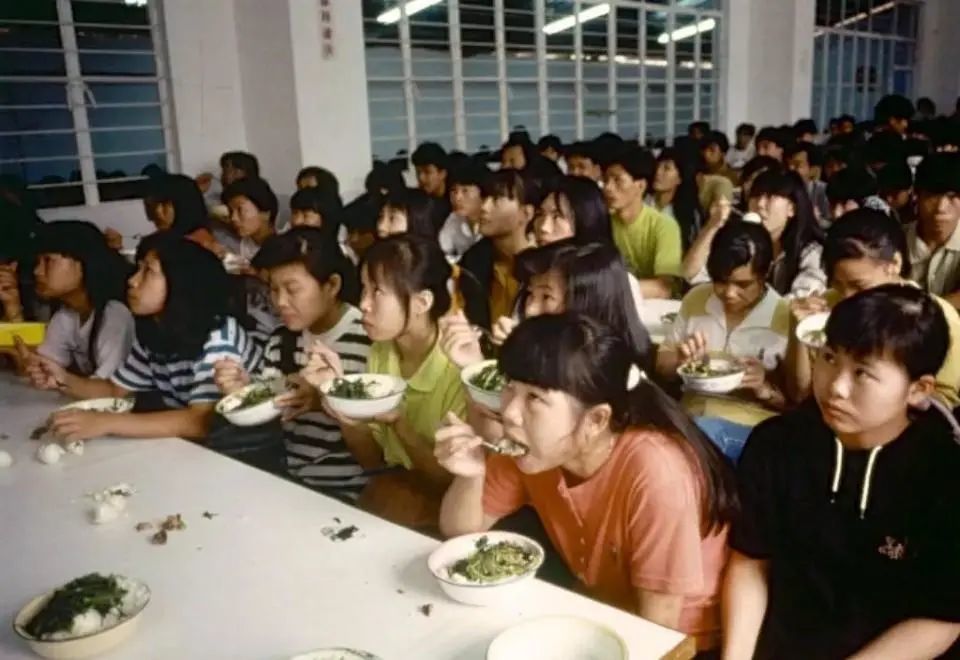 八十年代末,在深圳工厂的打工妹,边吃饭边看电视.