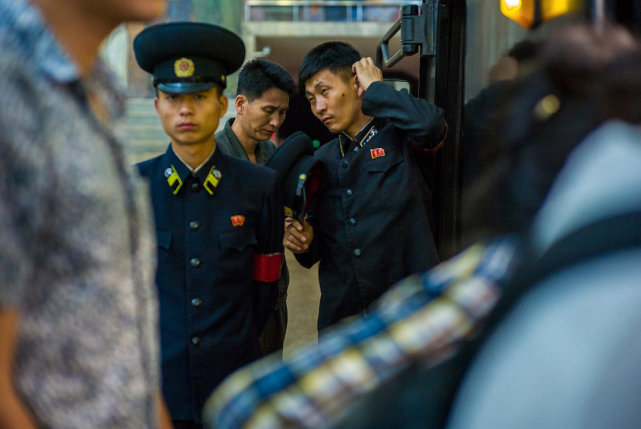 图为朝鲜平壤地铁站的男乘务员,他们都穿着制服,戴着大檐帽.