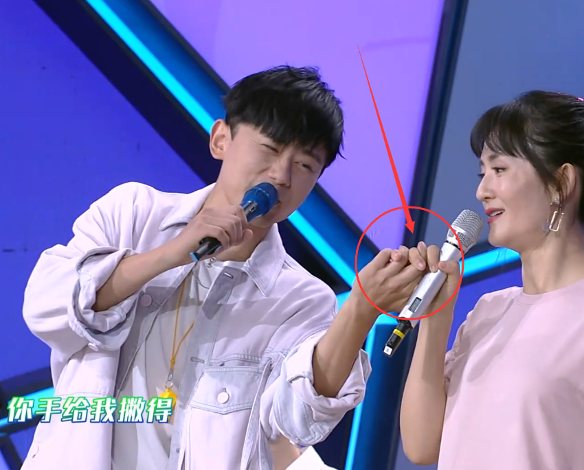 谢娜右手牵张杰左手牵何炅谁注意她怎么举话筒张杰脸色变了