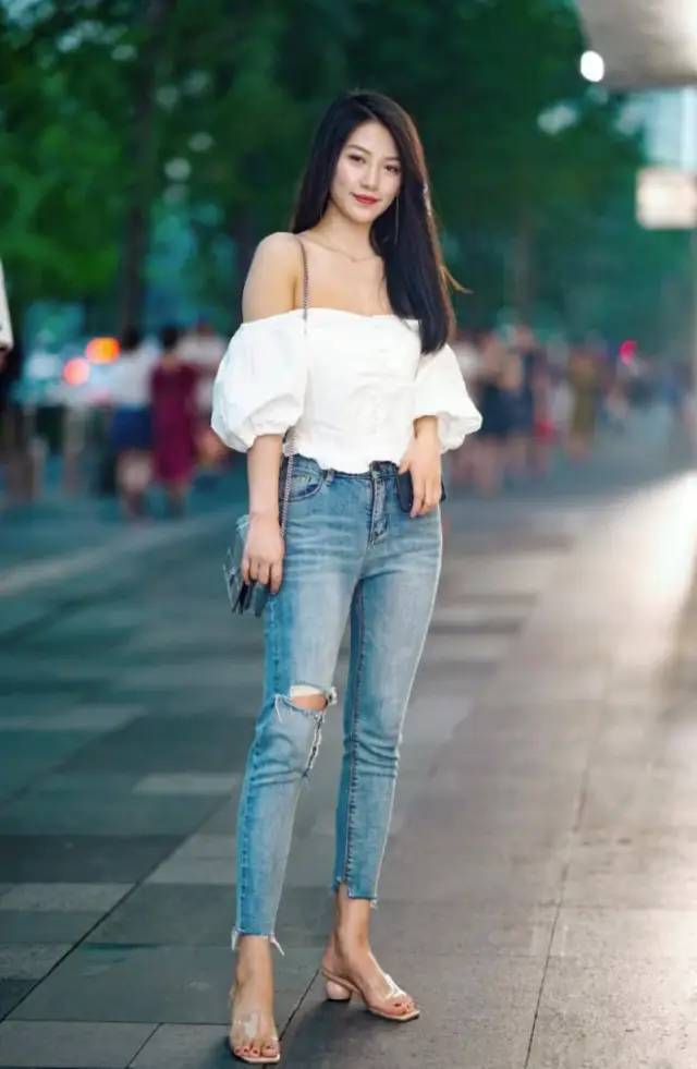 美女穿破洞牛仔裤,搭配抹胸上衣,穿水晶拖鞋,气质绝佳