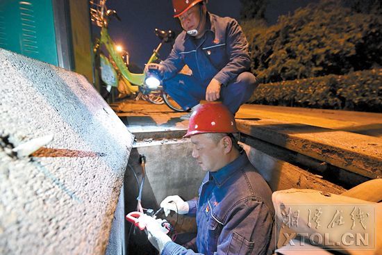 夜晚,灯饰管理处的工作人员在巡查检修路灯.