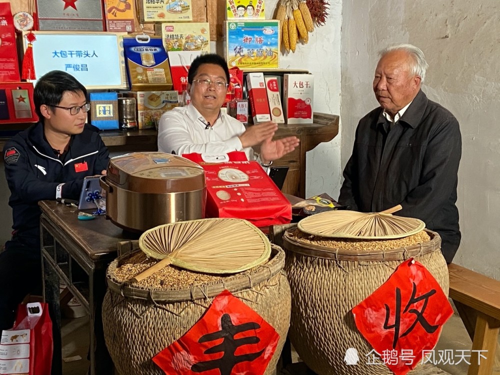 请来大包干带头人严俊昌(右一"在当年农家"摆放的特色农产品小岗村