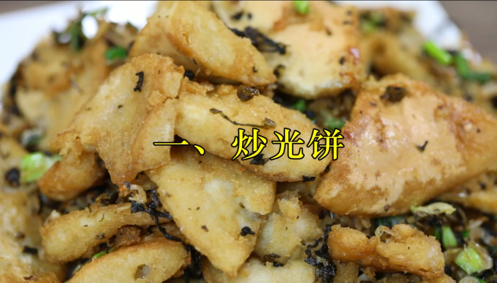 往锅里倒入些许油,放入蒜头,酸菜,虾米翻炒,光饼倒入锅中继续炒.