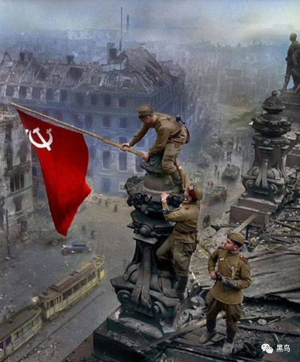的苏联红军士兵攻克柏林时在柏林国会大厦穹顶上升起胜利旗帜的照片