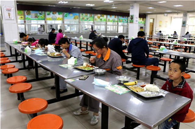 妈妈和孩子一起在学校食堂就餐