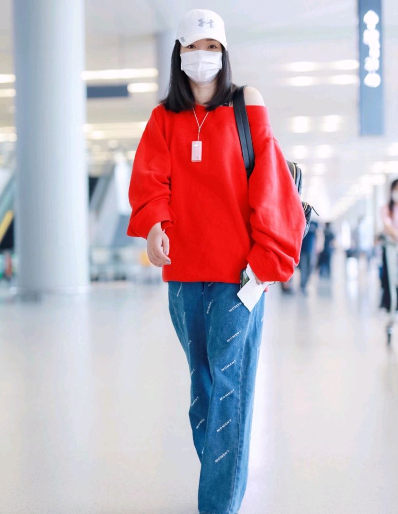 柳岩的机场look,身穿红色露肩卫衣搭配蓝色牛仔裤,显嫩还很时髦