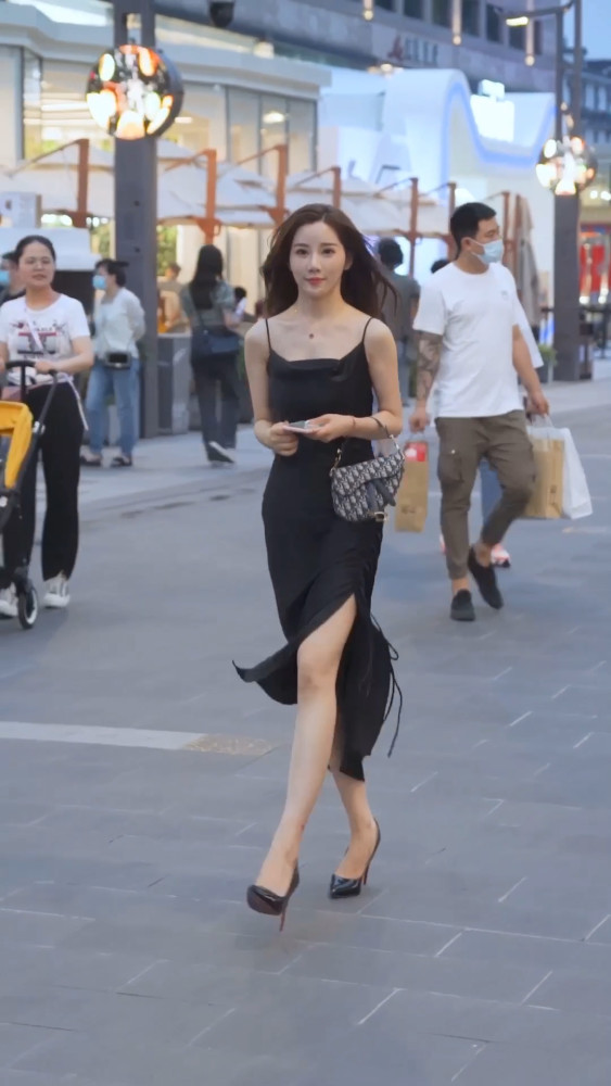 街拍:美女为显腿长穿上"恨天高",搭配黑色连衣裙,尽显