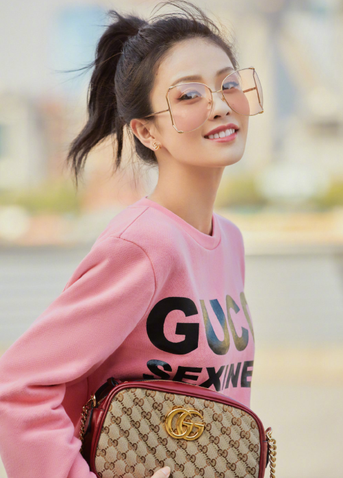 白鹿身穿粉色卫衣搭配gucci手袋,清爽的高马尾造型