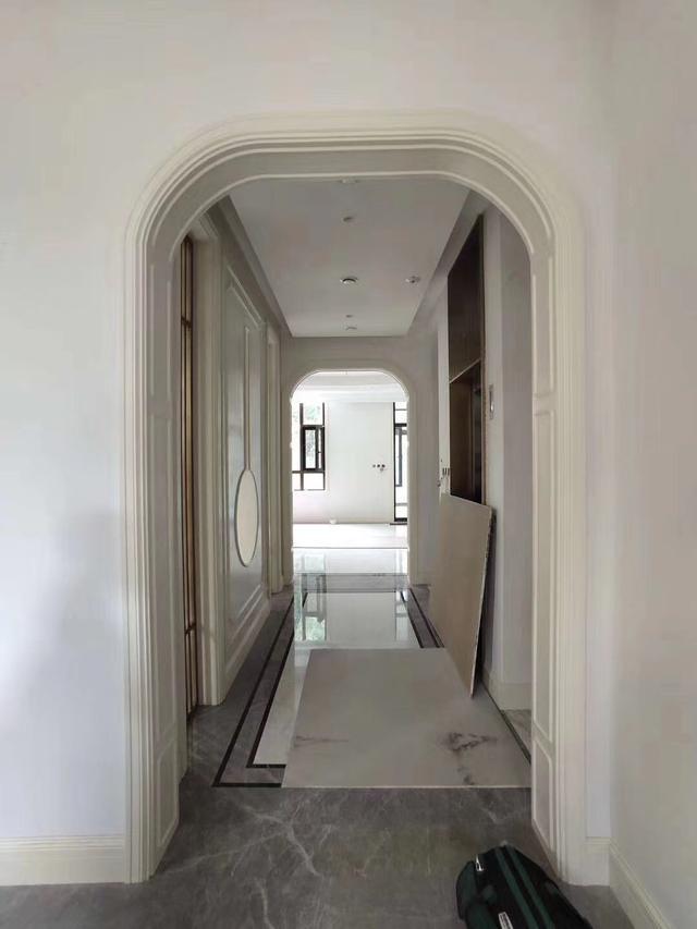 进门过道的造型是圆形拱门的样子,两边进去是卧室,对面四客厅