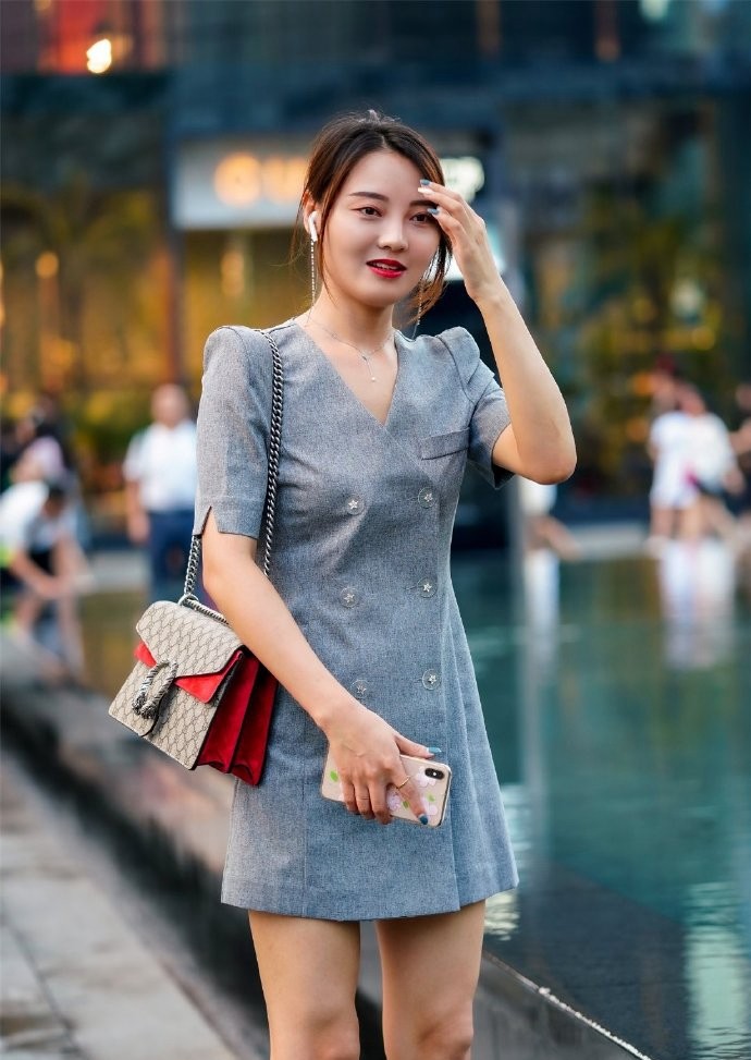 气质辣妈逛街走累了,坐在石头上休息,端庄的样子像极了爱情