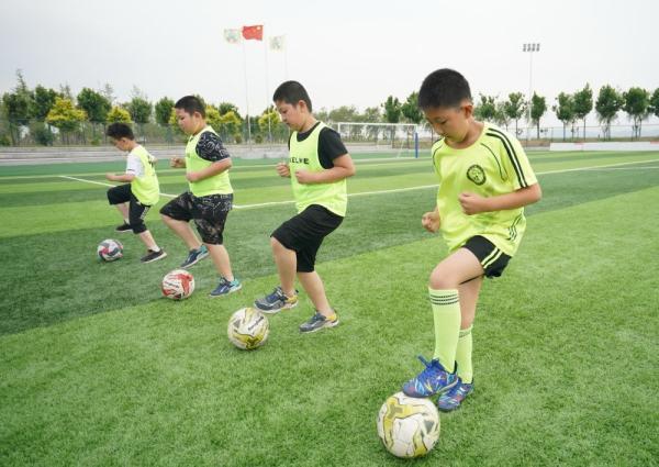 6月17日,在河北省迁安市伟华青少年足球训练活动中心,孩子们在训练中.