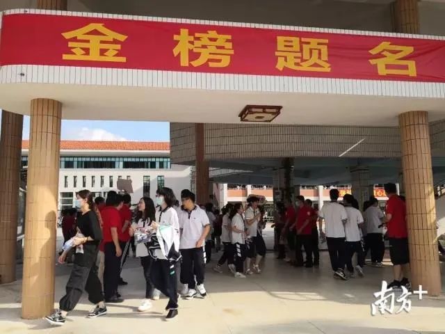 在三水区实验中学考点内,悬挂"金榜题名"横幅,学校老师身穿红色衣服