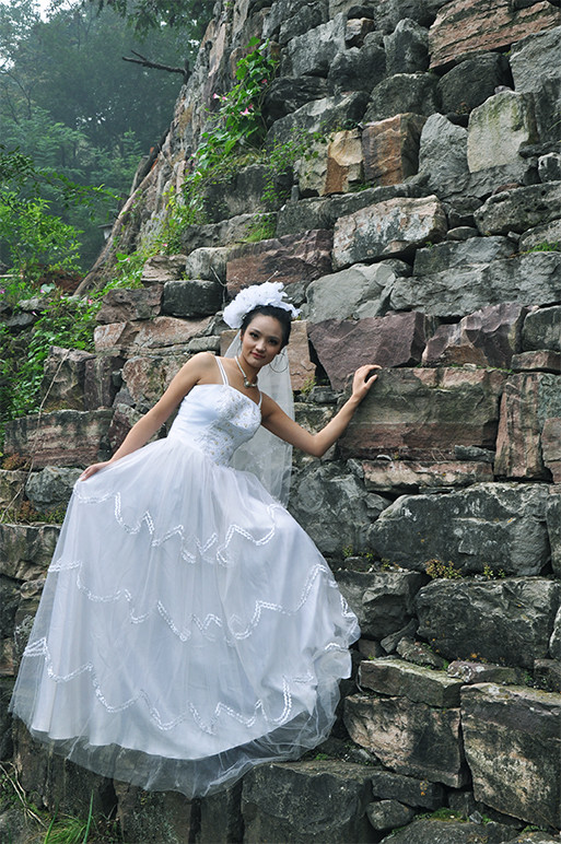 大山里美丽的风景,穿上白色婚纱的她,在一块巨石山躺着,就像刚刚从天