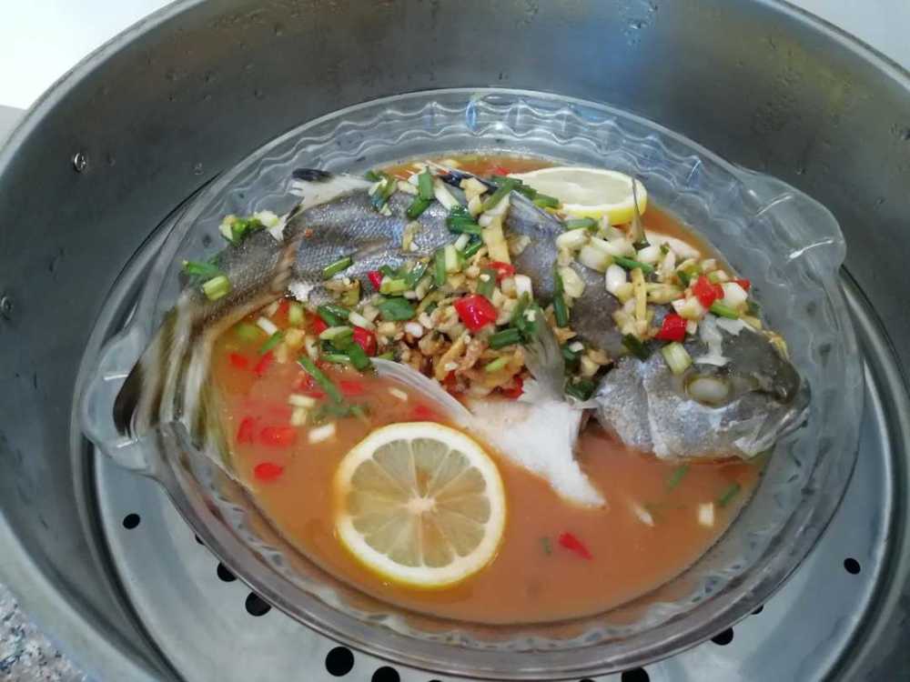鯻鱼蒸5分钟后,出锅,将蒸鱼的腥水倒掉,再把料汁与番茄汁淋在鱼身上